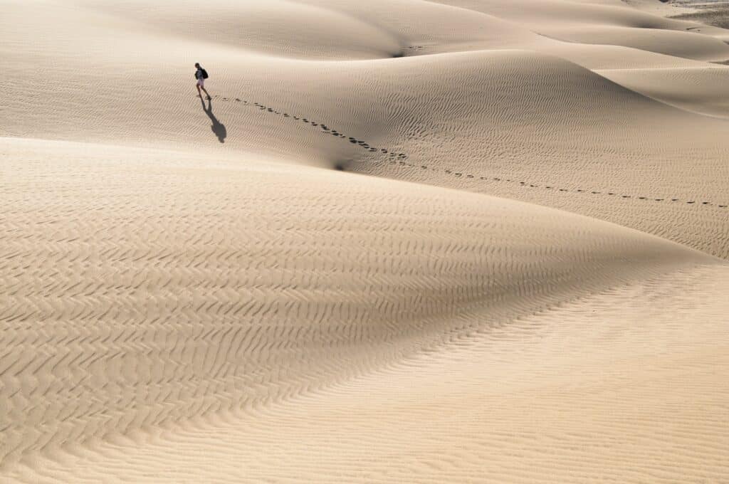 Minimalistic photo of a person walking in a big desert